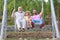 Men family playing on swing together Excited grandfather, amazed father and funny son swinging together in park outdoors