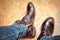 Men fashion legs in blue jeans and brown leather boots