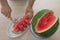 Men hand hold from on fresh watermelon cutting for eatin on table background