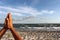 Men hands in praying sign on sand beach by the sea against blue sky with clouds.