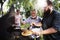 Men helping cooking homemade steak at bakcyard summer party