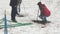 Men with a jackhammer and crowbar make holes in the frozen ground