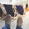 Men legs in sneakers on background of deckchairs on beach