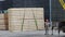 Men load a wooden beam into the car, loading the cargo into the car using a crane