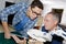 Men looking at object through magnifier and holding tablet