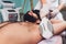 Men lying at beautician& x27;s during laser armpit hair removal therapy.