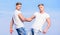 Men muscular twins brothers in white shirts sky background. Brotherhood concept. Benefits and drawbacks of having