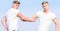 Men muscular twins brothers in white shirts sky background. Brotherhood concept. Benefits of having twin brother