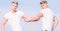 Men muscular twins brothers in white shirts sky background. Brotherhood concept. Benefits of having twin brother