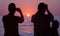 Men photographing sunrise at sea