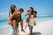 Men piggybacking women holding softdrink bottle