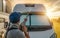 Men Pressure Washing His Camper Van RV During Scenic Sunset