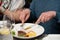 Men in a restaurant eating medium grilled cut pork steak with blood on the plate with parsnip puree and corn