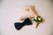 Men`s accessories, bow tie, wedding golden rings, boutonniere on a white table. Businessman clothing detail concept.