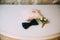 Men`s accessories, bow tie, wedding golden rings, boutonniere on a white table. Businessman clothing detail concept