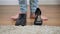 Men`s boot and women`s high heel shoe standing on the floor, male Caucasian feet coming up. Intersex person choosing