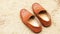 Men`s brown color loafers shoes on sand background