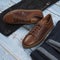 Men`s casual outfits for man clothing set with shoes, trousers, shirt on wooden background, Top view