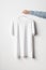 Men`s Crew Neck T-Shirt Mock-Up - Man holding a white t-shirt on a copper wire clothes hanger