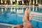 Men`s feet on the background of the swimming pool, relax on vacation