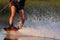 Men\'s feet on a wakeboard in water.guy on the river and is preparing to go wake boarding