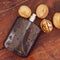 Men's fragrance for strong-minded men in a black bottle on a vintage wooden board with nuts