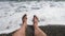 Men`s hairy legs in sea surf. Parallel lying bare legs.