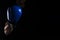 Men`s hand in a blue boxing glove on a black background makes a punch - hook