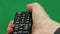 Men`s hand. Large remote control. Right hand. Green screen. Press the button.