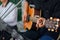 A Men`s hand playing guitar with friends during the live performance on stage.