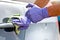 Men`s hand in protective gloves cleaning car door handle using antibacterial or cleaning solution