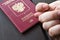 Men`s Hand shows the fico on passport backgound. Symbol of sanctions. Negative concept. Closeup