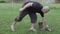 Men\'s hands chop firewood with an ax on a special stump on the background of beautiful green grass