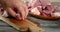 Men`s hands with a knife slice raw pork for kebab.