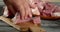 Men`s hands with a knife slice raw pork for kebab.