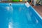 Men`s hands pour light liquid from a plastic tank into a pool, into water. chemical water purification, alkali balance, unsanitar