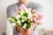 Men`s hands stretch a bouquet of spring flowers. Bouquet of pink and white tulips closeup and copy space