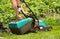 Men`s hands are taken from an electric lawnmower grass receiver. He mowed grass in the garden