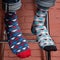 On men`s legs different colored socks, on a background of a brick wall, concept