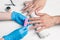 Men`s manicure. Cosmetologist in rubber gloves file nails on male hands.