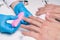 Men`s manicure. Cosmetologist in rubber gloves file nails on male hands.