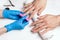 Men`s manicure. Cosmetologist in rubber gloves file nails on male hands.