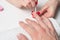 Men`s manicure. the hands of the beautician treated cuticle of men`s hands using the orange sticks