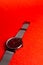 men's metal watch close-up on a red background