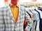 Men`s plaid blazer on a mannequin and shirts on hangers