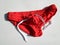 Men`s red swimming briefs on white background