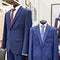 Men`s suits with shirts and ties in clothing store