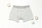 Men`s underwear, gray underpants and cotton flowers on white background flat lay top view copy space. Fashion blog, natural