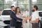 Men shaking hands, couple purchasing automobile.