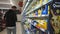 Men shopping at grocery without cart. Picking food from shelves at supermarket.